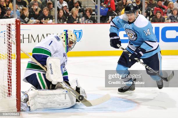 Goaltender Roberto Luongo of the Vancouver Canucks makes a save on the power play as Chris Kunitz of the Pittsburgh Penguins moves in looking for the...