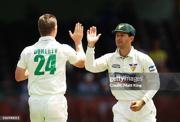 Ricky Ponting of the Tigers celebrates with bowler Xavier Doherty after taking a catch to dismiss Moises Henriques of the Blues during day two of the...