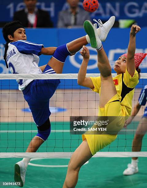 Le Thi Hanh of Vietnam competes against Mega Citra Kusuma Dewi of Indonesia at the sepak takraw women's team preliminary round group A match during...