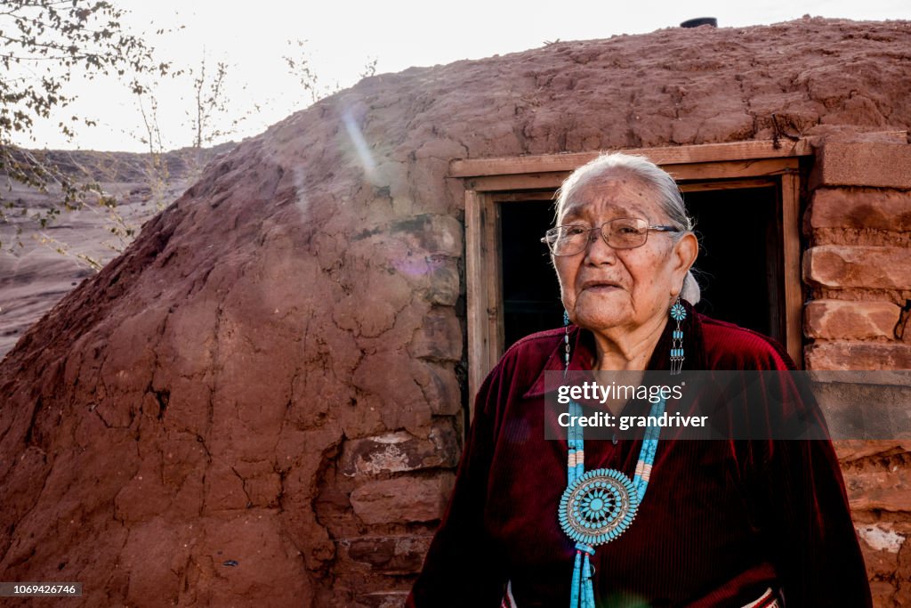 Senior indianische Navajo Frau im Monument Valley außerhalb eines traditionellen Hogan