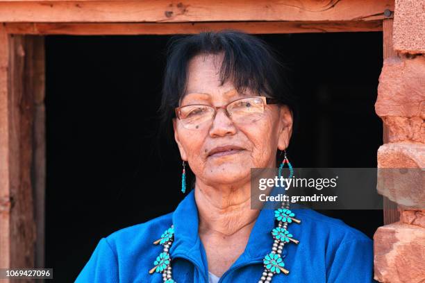 sessenta e cinco ano de idade sênior nativo americana navajo mulher bonita posando dentro de um autêntico hogan - 63 year old female - fotografias e filmes do acervo