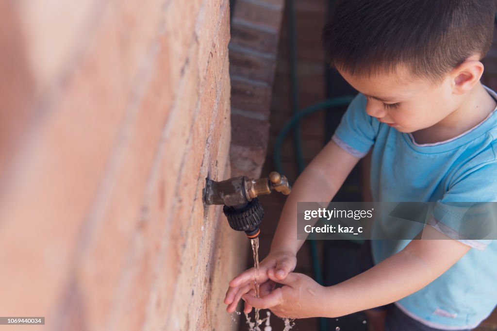 Kleiner Junge seinem Händewaschen an einer Outdoor-Armatur