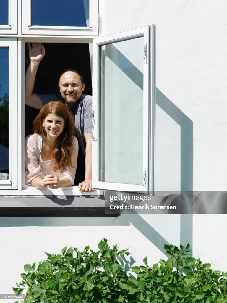 Adult couple looking through open window