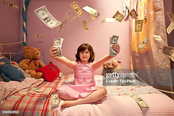 a young girl throwing money in the air. - reichtum stock-fotos und bilder