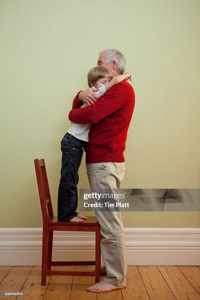 Young boy and his grandfather embracing.