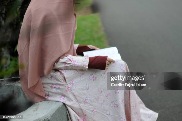 asian muslim woman reading book - fajrul islam stock pictures, royalty-free photos & images