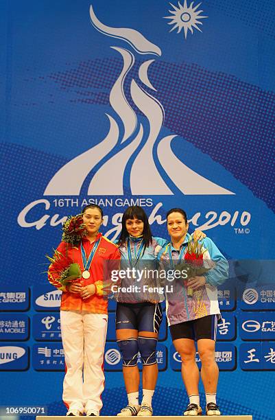 Silver medalist Cao Lei of China, gold medalist Svetlana Podobedova of Kazakhstan and bronze medalist Tatyana Khromova of Kazakhstan celebrates...