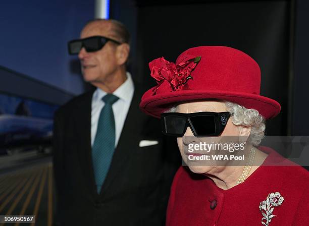Queen Elizabeth II and Prince Philip, Duke of Edinburgh wear 3 D glasses to watch a display and pilot a JCB digger, during a visit to the University...