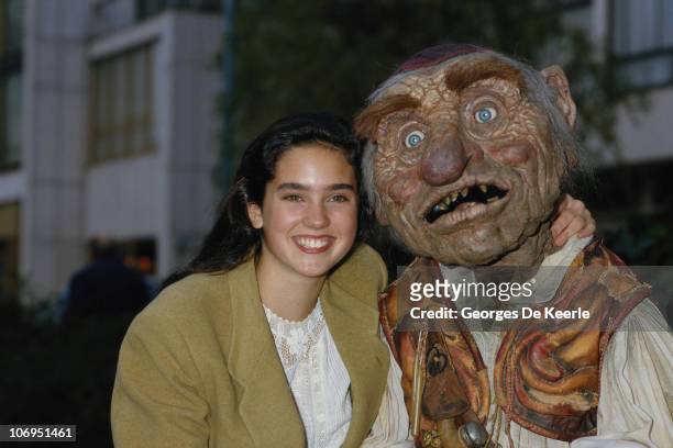 American actress Jennifer Connelly with an actor in the costume of the dwarf 'Hoggle', during filming of 'Labyrinth', directed by Jim Henson, UK, 1st...