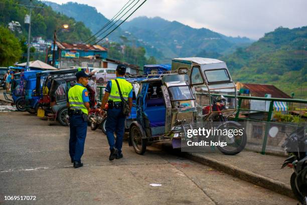 banaue street with two police man walking, ifugao, philippines - philippines tricycle stock pictures, royalty-free photos & images