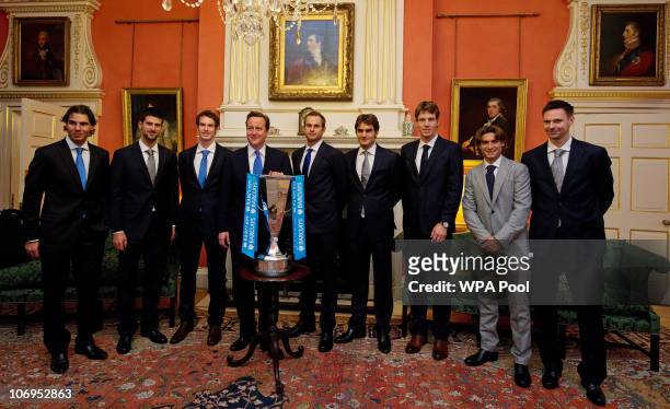British Prime Minister David Cameron poses in front of the ATP World Tour Finals trophy with contenders Rafael Nadal of Spain, Novak Djokovic of...