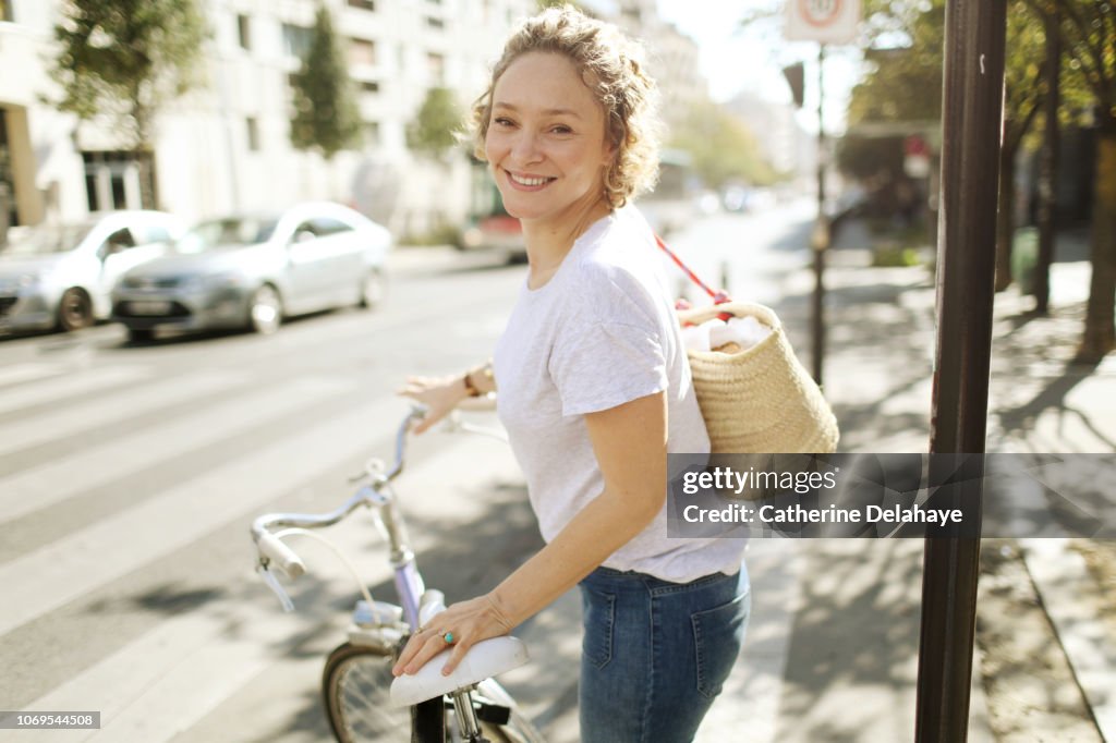 A 40 years old parisian woman with her bike in the streets of Paris