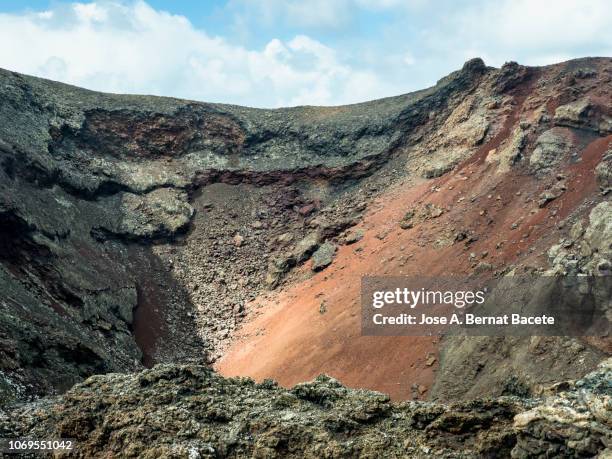 volcanic landscape with mountains and craters a day of blue sky with white clouds. timanfaya national park, lanzarote, canary islands, spain. - lava stock pictures, royalty-free photos & images
