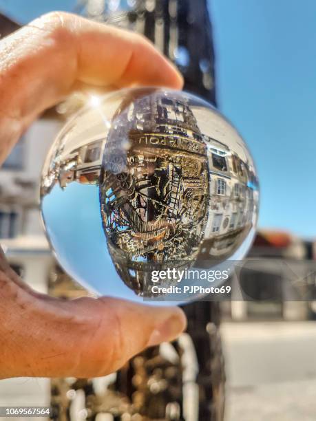 bronze funtain in oberammergau watched through lensball - germany - oberammergau stock pictures, royalty-free photos & images