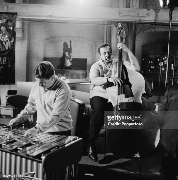 American jazz double bassist Charles Mingus pictured performing with English jazz musician Tubby Hayes during a recording for the film 'All Night...