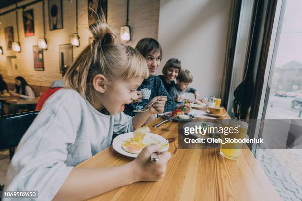 gezin met twee kinderen eten in café - brunch restaurant stockfoto's en -beelden