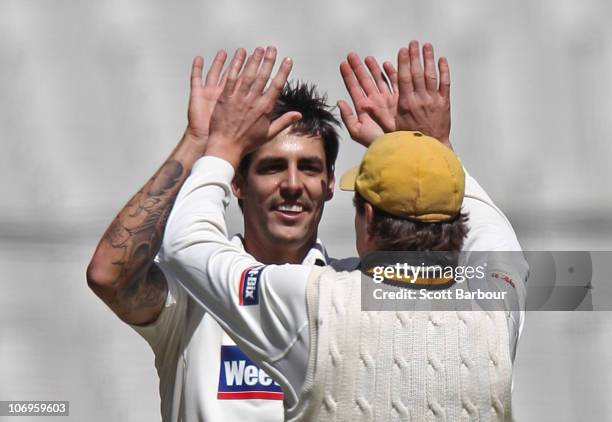 Mitchell Johnson of the Warriors celebrates with Marcus North after dismissing Rob Quiney of the Bushrangers during day three of the Sheffield Shield...