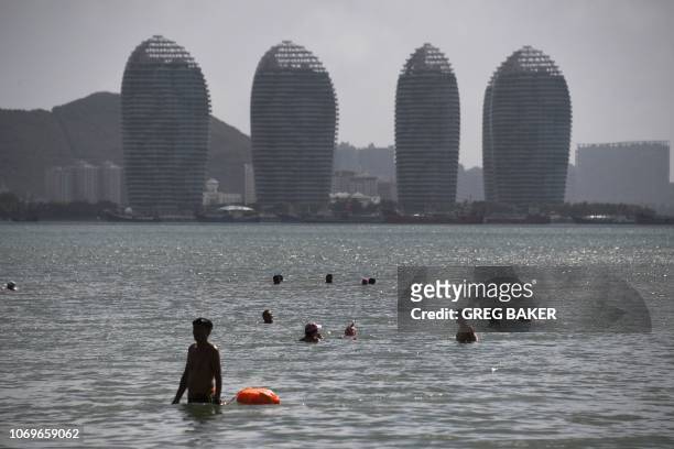 People swim at a beach in Sanya on China's tropical Hainan Island on December 8, 2018.