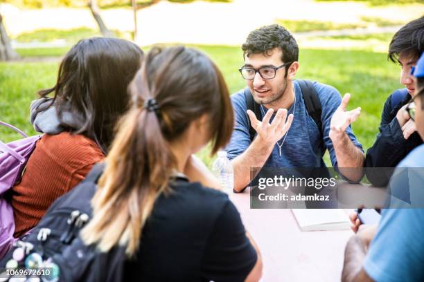 groep van uiteenlopende studenten rond de tafel - filosofie stockfoto's en -beelden