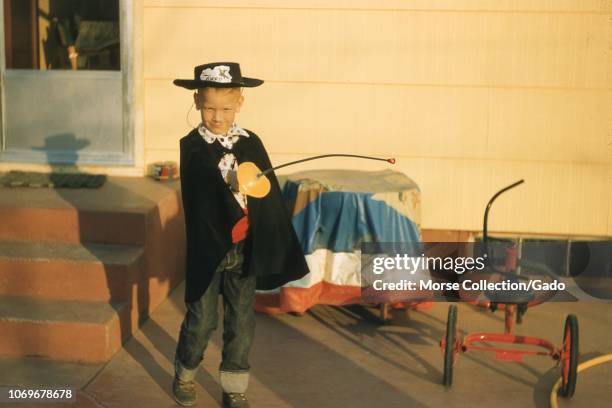 Portrait of a young boy dressed as the character Zorro, posing in the late afternoon sun outside his home in Ogden, Utah, October 31, 1958.