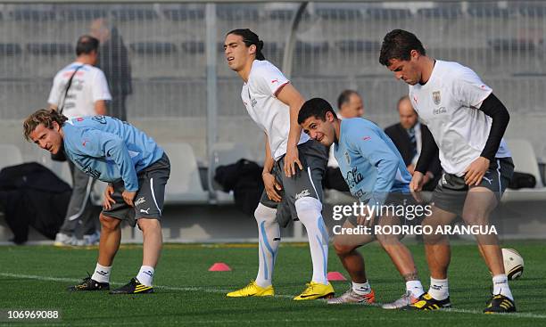 Uruguay's striker Diego Forlan and teammates stretch during a training session in Phillippi stadium in Cape Town on July 5, 2010 on the eve of their...