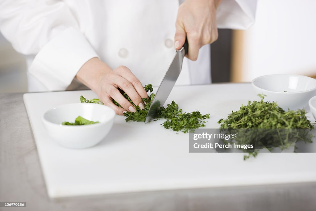 Cook chopping fresh parsley 