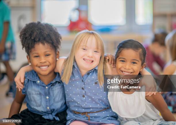 three diverse friends at kindergarten - special needs children stock pictures, royalty-free photos & images