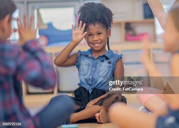 children waving in kindergarten class - deaf signing stock pictures, royalty-free photos & images