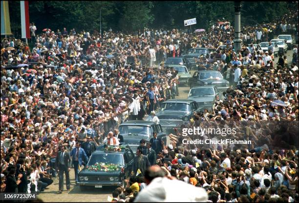 At the head of a motorcade, Pope John Paul II waves to the crowd from his car's sunroof, Poland, June 1979.