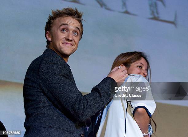 Actor Tom Felton signs a shirt of a fan during the Harry Potter 7 movie premiere at the Hipodromo de las Americas on November 18, 2010 in Mexico...