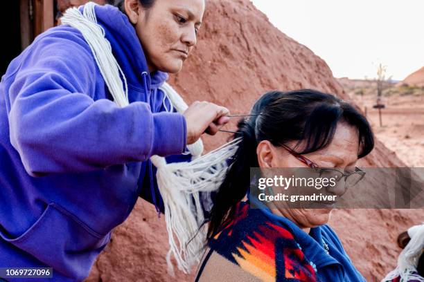 native american navajo woman styling another woman's hair in a traditional style - traditional native american medicine stock pictures, royalty-free photos & images