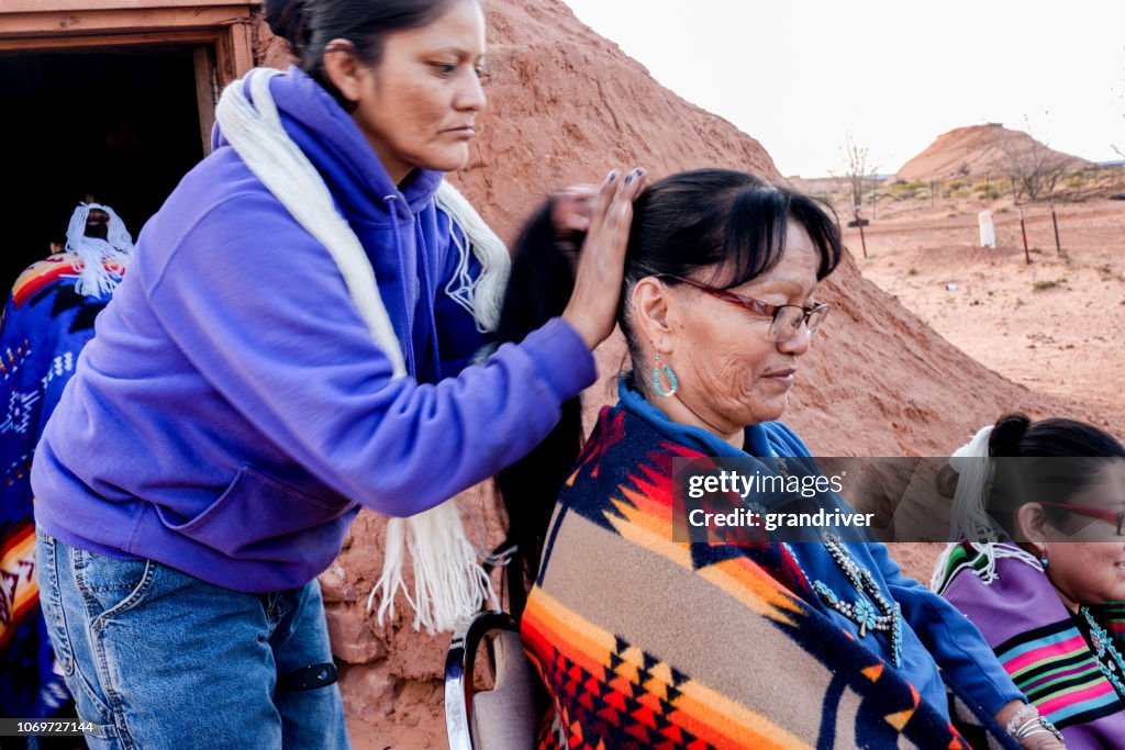 Native American Navajo Woman Styling another woman's hair in a traditional style