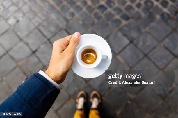 man holding cup of espresso coffee, personal perspective view - italian cafe culture stock pictures, royalty-free photos & images