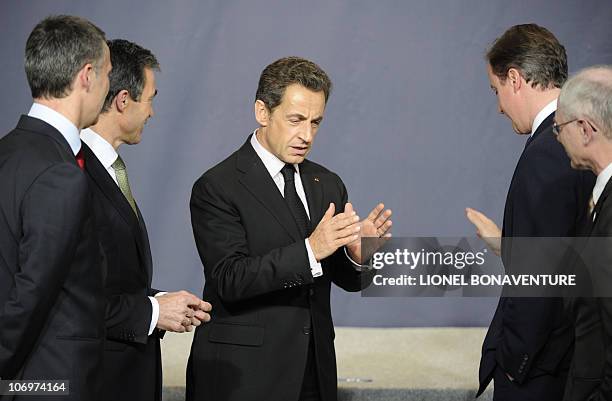 France's President Nicolas Sarkozy chats with United Kingdom's Prime Minister David Cameron after posing for a family picture after the NAC meeting...