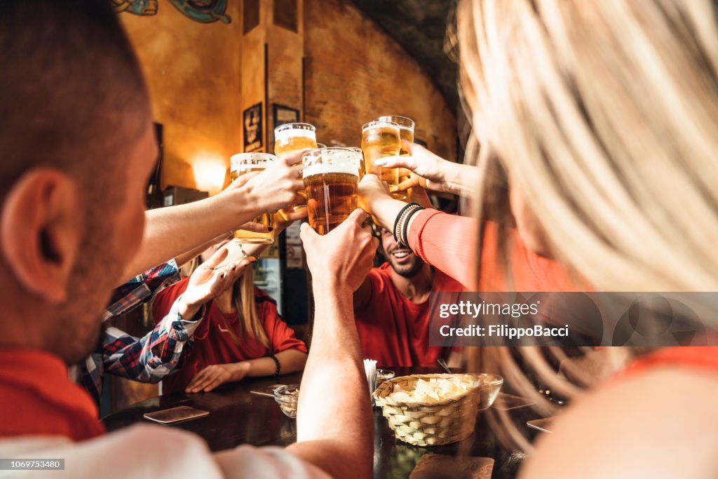 Grupo de amigos felizes bebendo cerveja na cervejaria