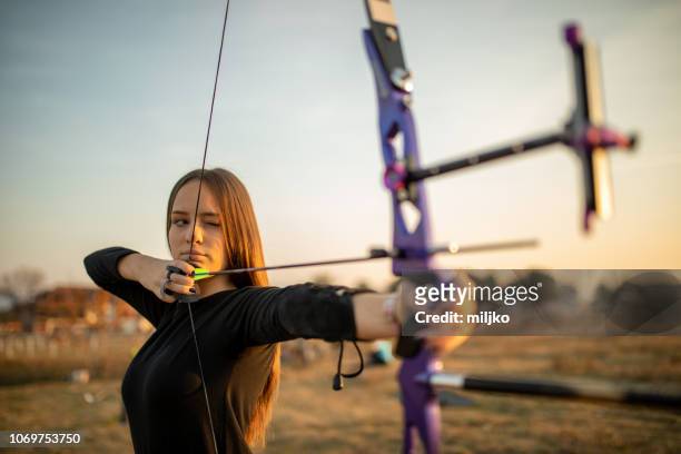 adolescente in allenamento di tiro con l'arco al tramonto - tiro con l'arco foto e immagini stock