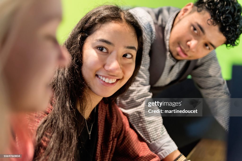 Multi-ethnic group of students working in College library.