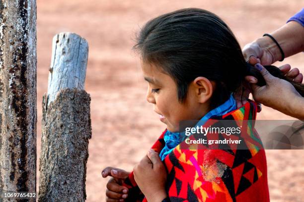 nine year old native american navajo boy having his hair styled - year long stock pictures, royalty-free photos & images