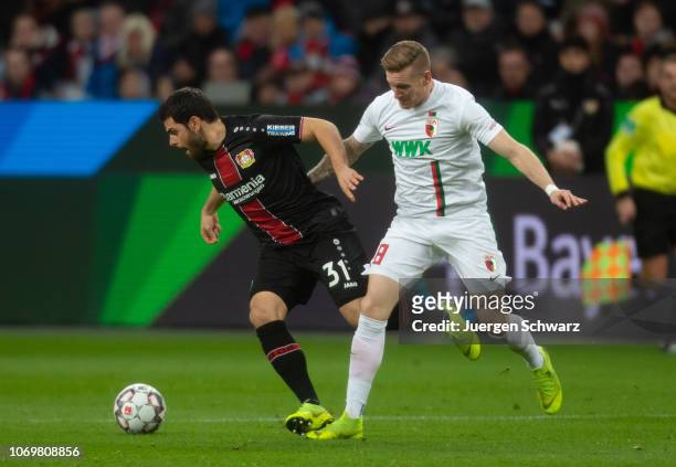 Kevin Volland of Leverkusen and Andre Hahn of Augsburg battle for the ball during the Bundesliga match between Bayer 04 Leverkusen and FC Augsburg at...