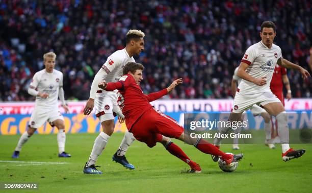 Thomas Mueller of Bayern Munich is challenged by Kevin Goden and Georg Margreitter of Nuernberg during the Bundesliga match between FC Bayern...