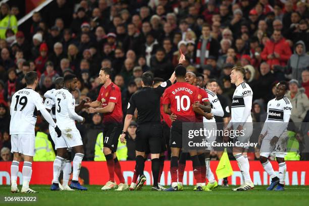 Andre-Frank Zambo Anguissa of Fulham is shown a yellow card by referee Lee Probert during the Premier League match between Manchester United and...