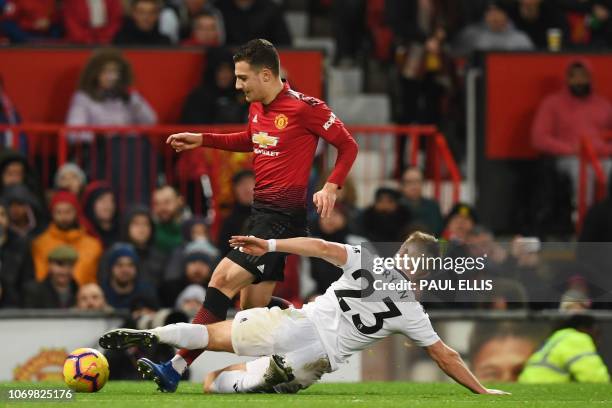 Manchester United's Portuguese defender Diogo Dalot is tackled by Fulham's English defender Joe Bryan during the English Premier League football...