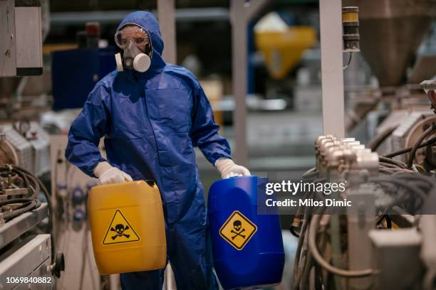 obrero trabajando con materiales peligrosos - traje nuclear fotografías e imágenes de stock