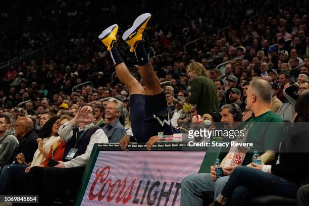 Gary Harris of the Denver Nuggets falls on the announcers desk during the first half of a game against the Milwaukee Bucks at Fiserv Forum on...