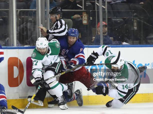 Cody McLeod of the New York Rangers runs into Alexander Radulov and Jamie Benn of the Dallas Stars during the third period at Madison Square Garden...