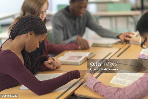 students praying together - theology stock pictures, royalty-free photos & images
