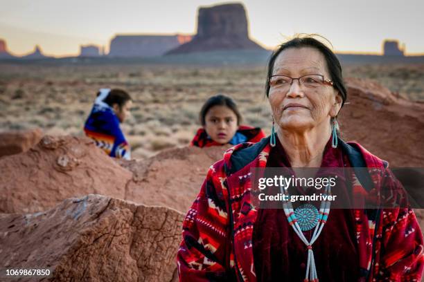 indianische großmutter, enkel und enkelin im monument valley in arizona in der morgendämmerung - aboriginal woman stock-fotos und bilder