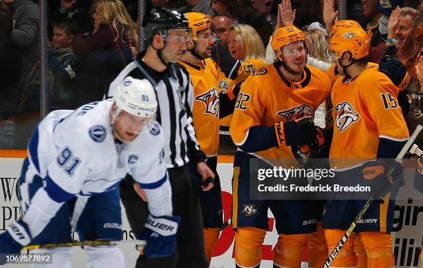 Steven Stamkos of the Tampa Bay Lightning skates by as Filip Forsberg and Craig Smith of the Nashville Predators congratulate teammate Ryan Johansen...