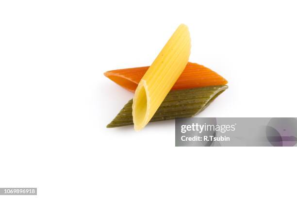 raw colored pasta isolated on white background. tomato, spinach and wheat - macarrones fotografías e imágenes de stock