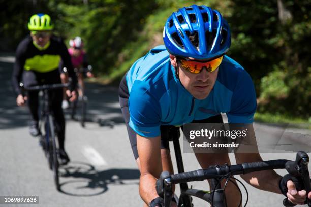 mannen en vrouw wegfietsen rijden op een bergweg - fietsevenement stockfoto's en -beelden